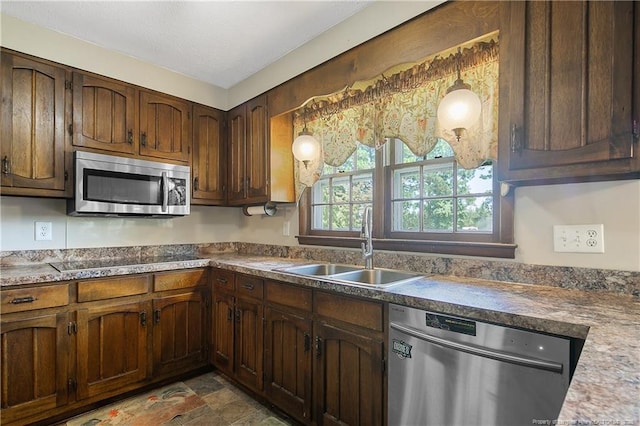 kitchen with pendant lighting, appliances with stainless steel finishes, and a sink