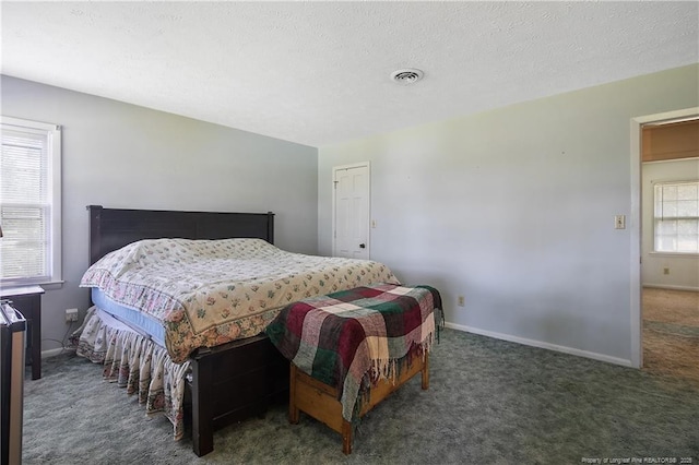 carpeted bedroom featuring visible vents, a textured ceiling, and baseboards