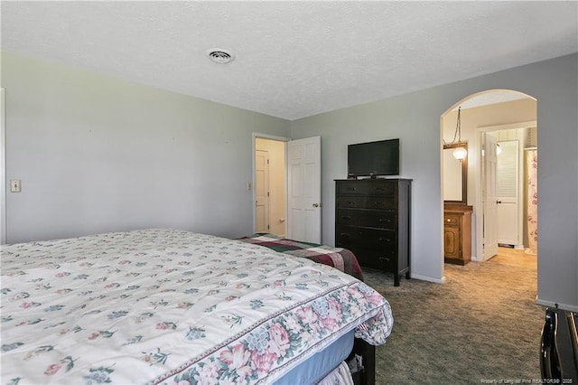 carpeted bedroom with baseboards, arched walkways, visible vents, and a textured ceiling