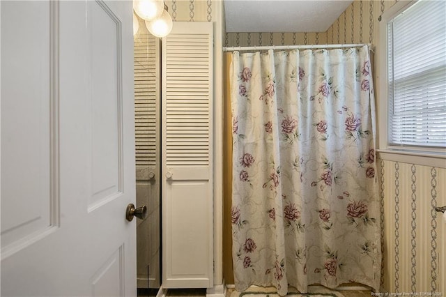 full bathroom with curtained shower and wallpapered walls