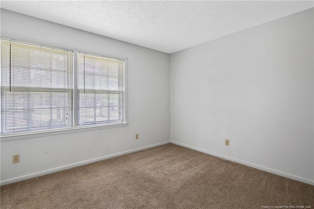 empty room featuring baseboards, carpet floors, and a textured ceiling