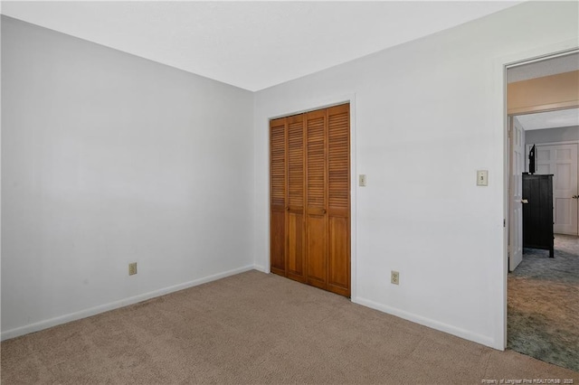 unfurnished bedroom with a closet, baseboards, and carpet floors