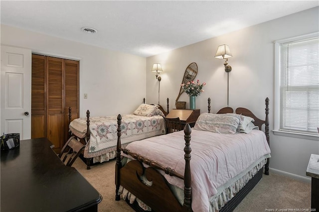 bedroom featuring light colored carpet, visible vents, a closet, and baseboards