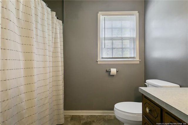 full bath featuring vanity, a shower with shower curtain, toilet, and baseboards