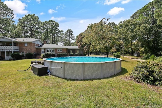 outdoor pool featuring a yard and central AC