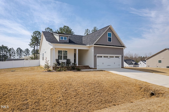 view of front of property featuring fence, a porch, roof with shingles, a garage, and driveway