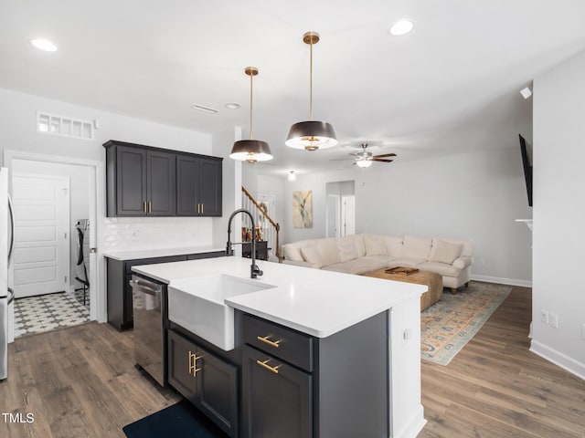 kitchen with a sink, stainless steel appliances, open floor plan, and light countertops