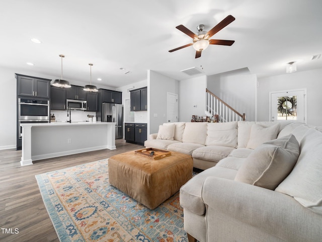 living area featuring visible vents, baseboards, recessed lighting, wood finished floors, and a ceiling fan