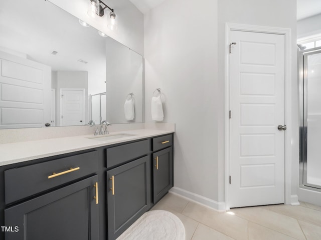 bathroom featuring baseboards, a stall shower, vanity, and tile patterned flooring