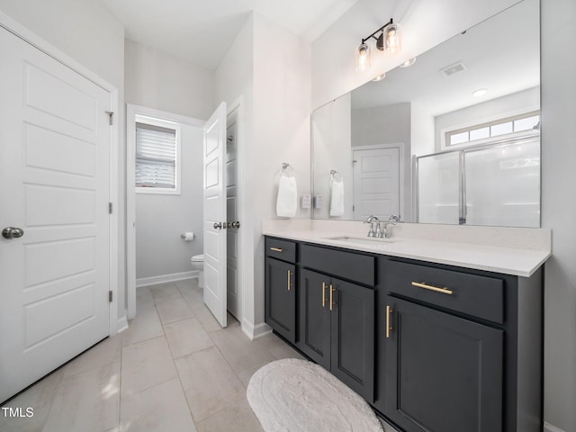 bathroom with tile patterned flooring, baseboards, toilet, a stall shower, and vanity