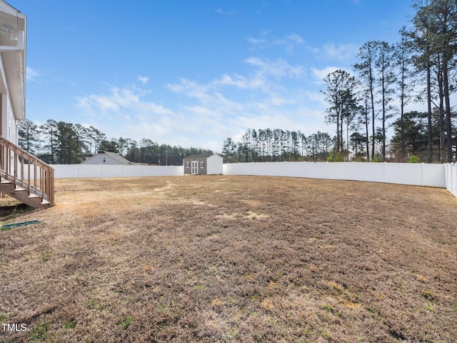 view of yard featuring an outdoor structure, a storage shed, and a fenced backyard