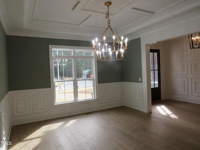 unfurnished dining area featuring an inviting chandelier, a decorative wall, wood finished floors, and a wainscoted wall