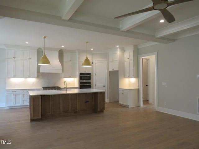 kitchen with beam ceiling, custom exhaust hood, and white cabinetry