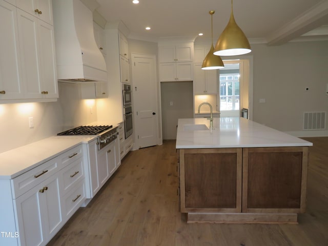 kitchen with visible vents, light wood-type flooring, custom range hood, stainless steel appliances, and a sink