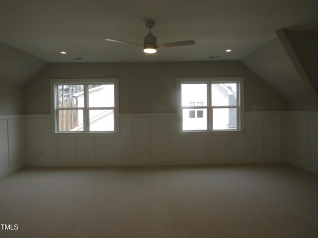 additional living space with carpet, lofted ceiling, recessed lighting, wainscoting, and a ceiling fan