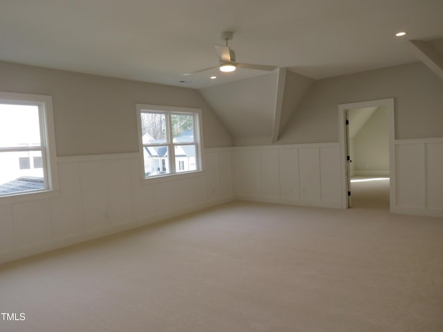 additional living space featuring a wainscoted wall, lofted ceiling, carpet flooring, recessed lighting, and a ceiling fan