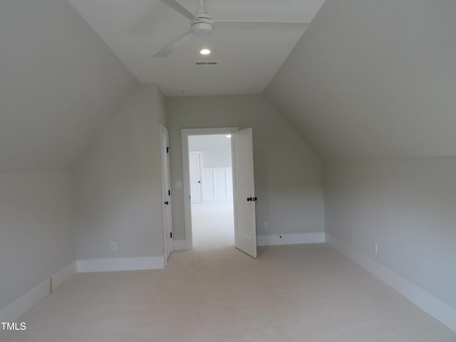 additional living space featuring visible vents, baseboards, ceiling fan, vaulted ceiling, and light colored carpet