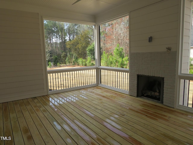 wooden terrace featuring a brick fireplace