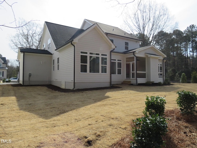 back of property with roof with shingles and a sunroom