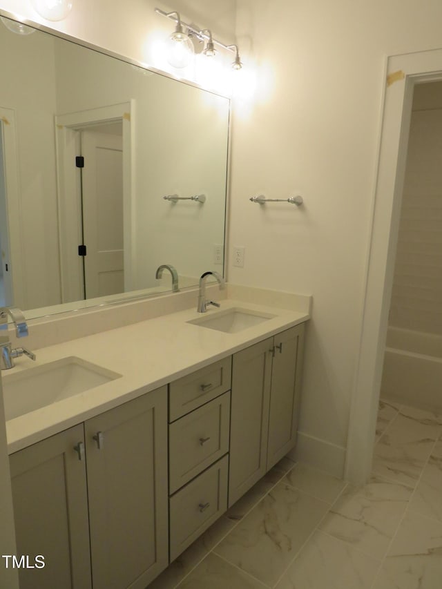 bathroom featuring double vanity, marble finish floor, and a sink