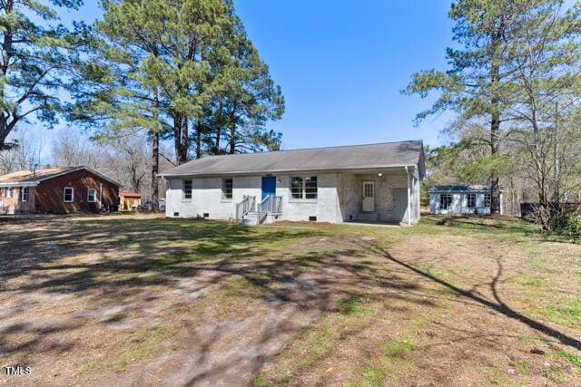 back of property featuring an attached carport and a yard