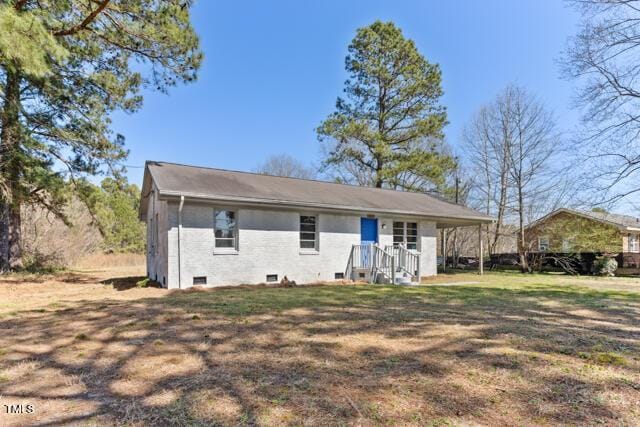 rear view of property featuring a lawn