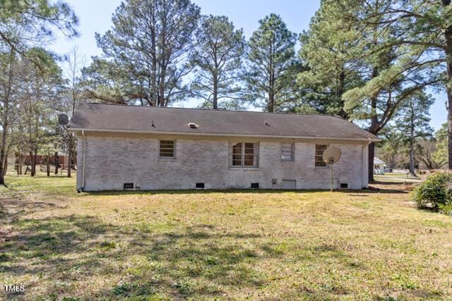 back of house featuring crawl space and a yard