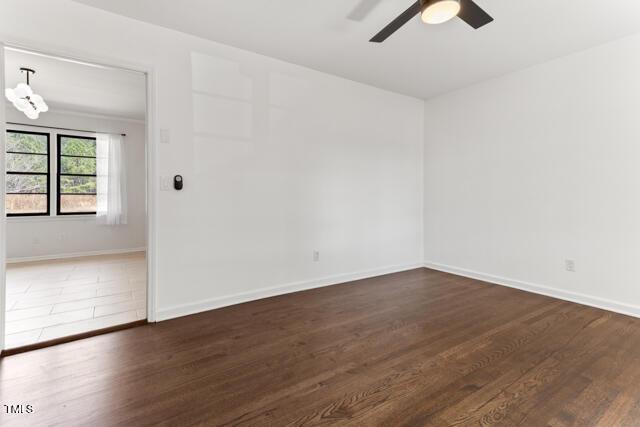 unfurnished room featuring baseboards, wood finished floors, and ceiling fan