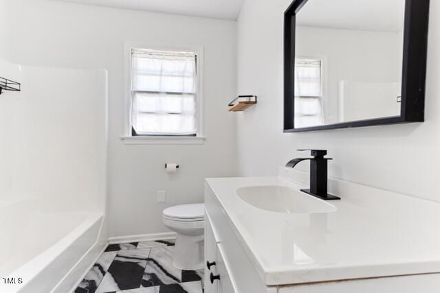 bathroom with vanity, toilet, baseboards, and marble finish floor