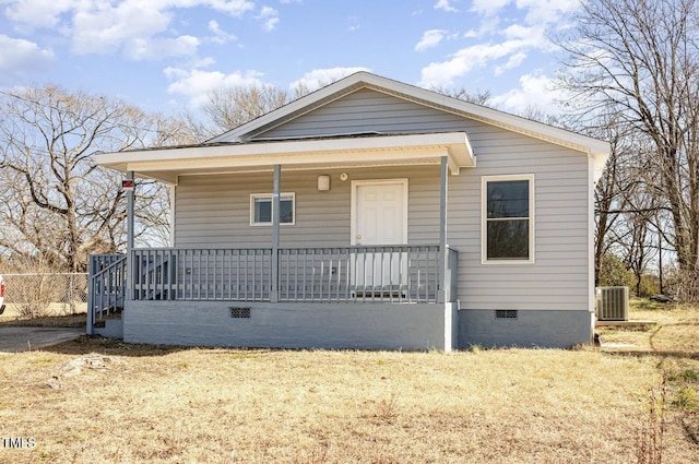 bungalow-style house featuring crawl space, a porch, cooling unit, and a front lawn