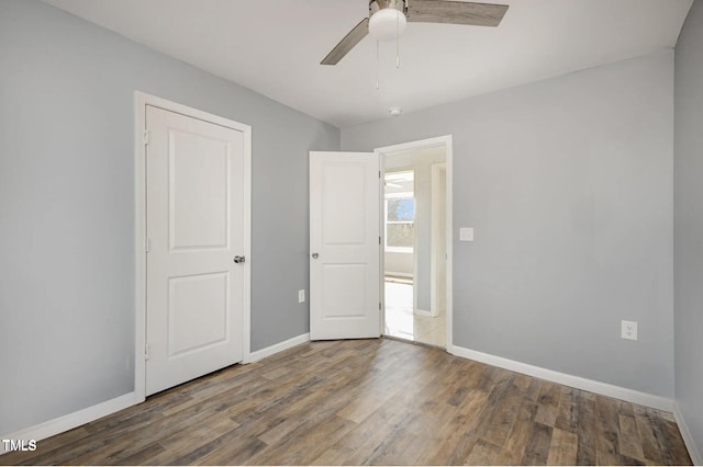 unfurnished bedroom featuring ceiling fan, baseboards, and wood finished floors