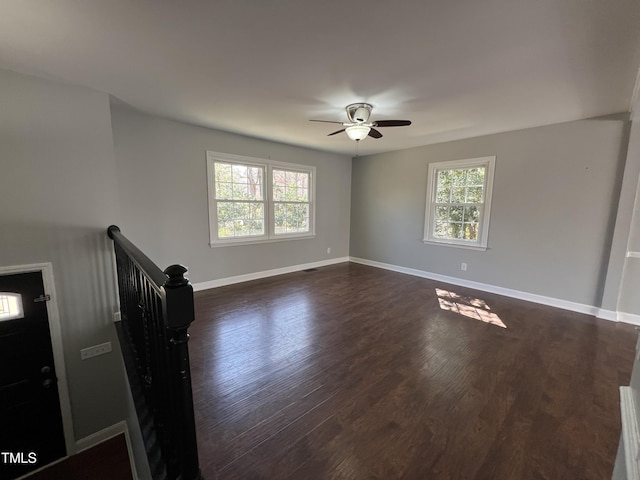 unfurnished room with plenty of natural light, baseboards, dark wood-type flooring, and ceiling fan