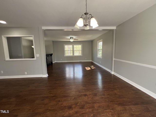 interior space with baseboards, wood finished floors, and ceiling fan with notable chandelier