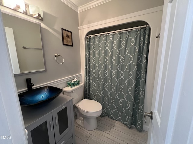 bathroom featuring a shower with shower curtain, vanity, toilet, and crown molding