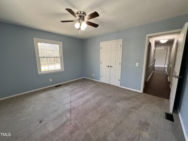 unfurnished bedroom with a closet, visible vents, carpet flooring, and baseboards