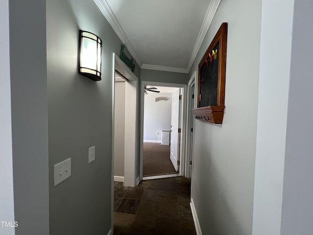 corridor with stone finish flooring, baseboards, and crown molding