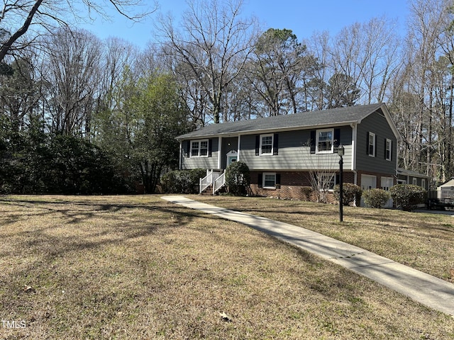 bi-level home with brick siding and a front lawn