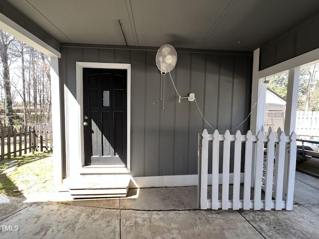 property entrance featuring fence and board and batten siding