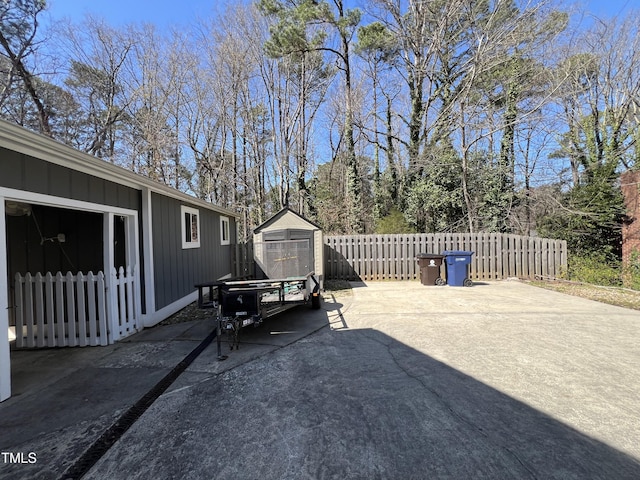 view of patio / terrace with an outbuilding, fence private yard, and a storage shed