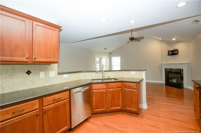 kitchen featuring a sink, open floor plan, a peninsula, dishwasher, and ceiling fan