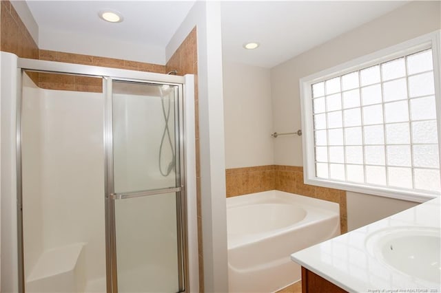 full bath featuring recessed lighting, a shower stall, a bath, and vanity