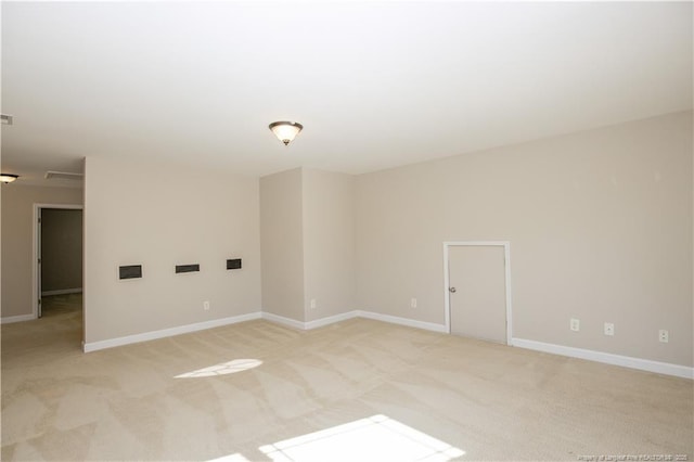 unfurnished room featuring visible vents, light colored carpet, and baseboards