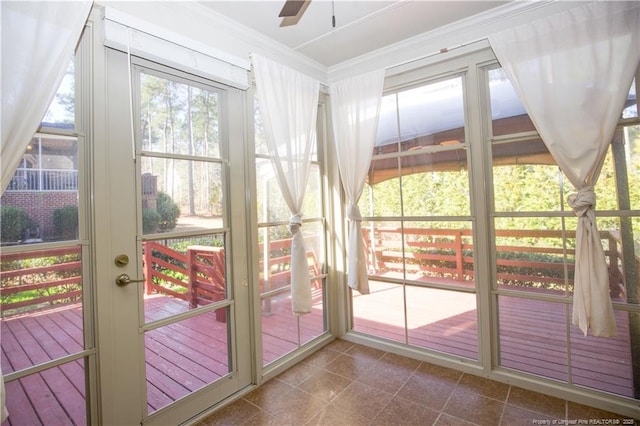 unfurnished sunroom with ceiling fan