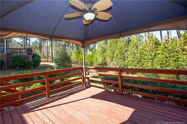 wooden deck with a ceiling fan and fence