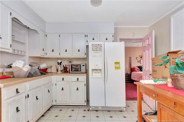 kitchen featuring stainless steel microwave, white cabinets, white refrigerator with ice dispenser, and light countertops