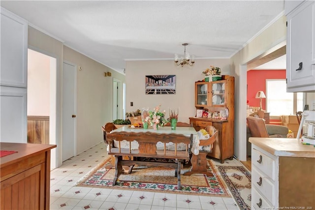 dining room with a notable chandelier, light floors, a textured ceiling, and crown molding