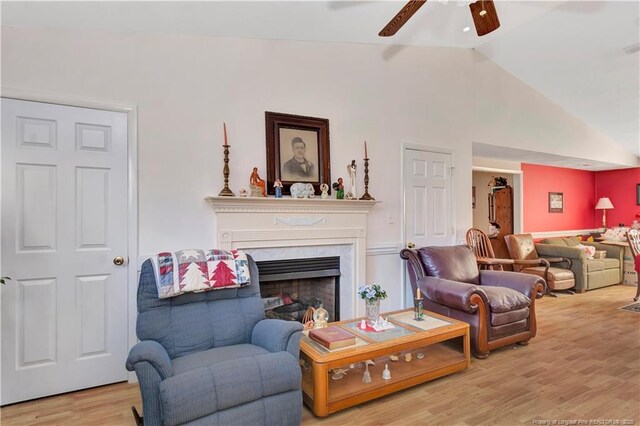 living room featuring a fireplace, wood finished floors, a ceiling fan, and vaulted ceiling