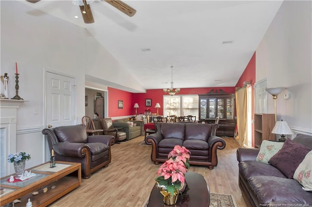 living room with visible vents, high vaulted ceiling, a ceiling fan, and wood finished floors