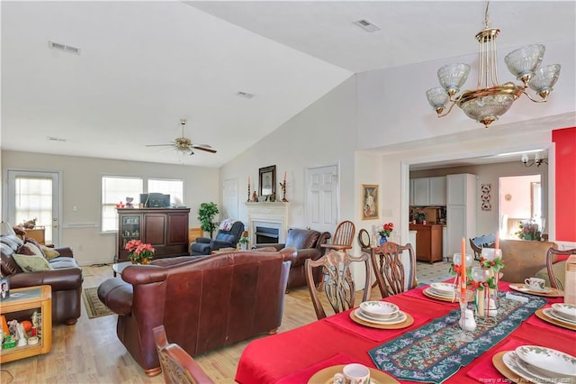 living room with lofted ceiling, a ceiling fan, visible vents, and light wood-type flooring