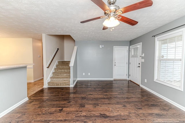 entryway featuring stairway, baseboards, wood finished floors, and a ceiling fan